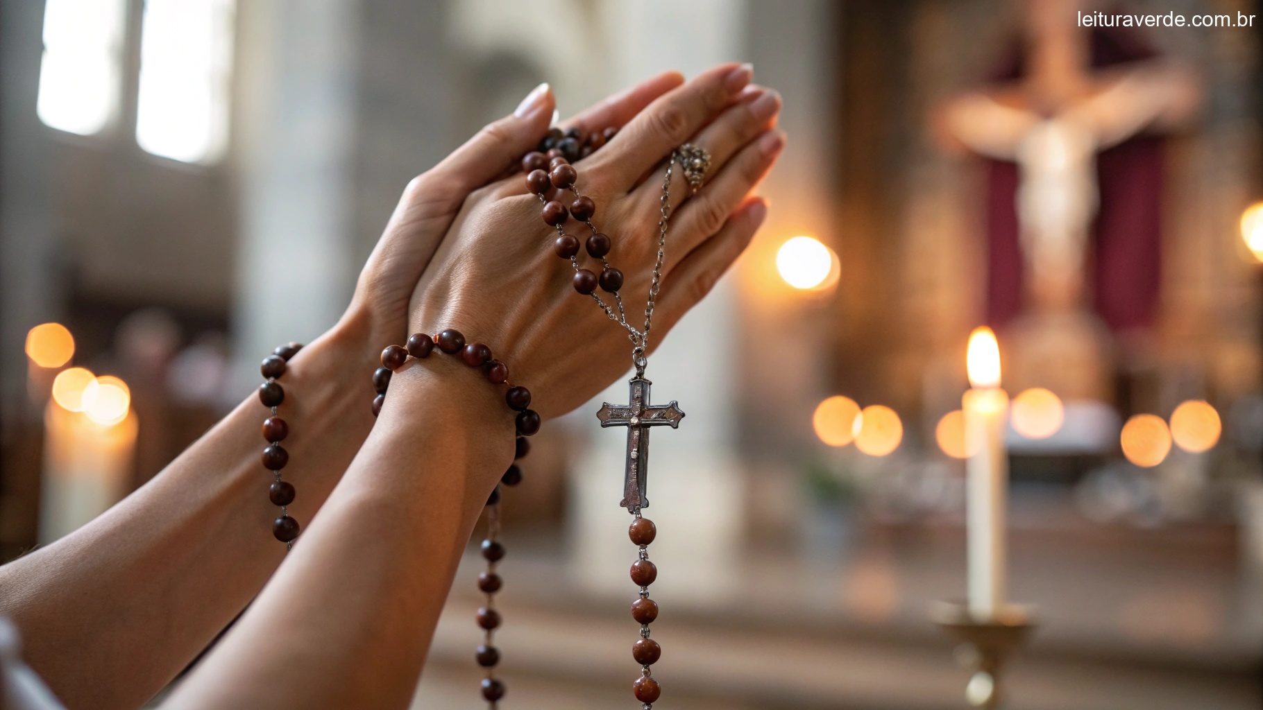 Mãos segurando um terço com velas acesas ao fundo